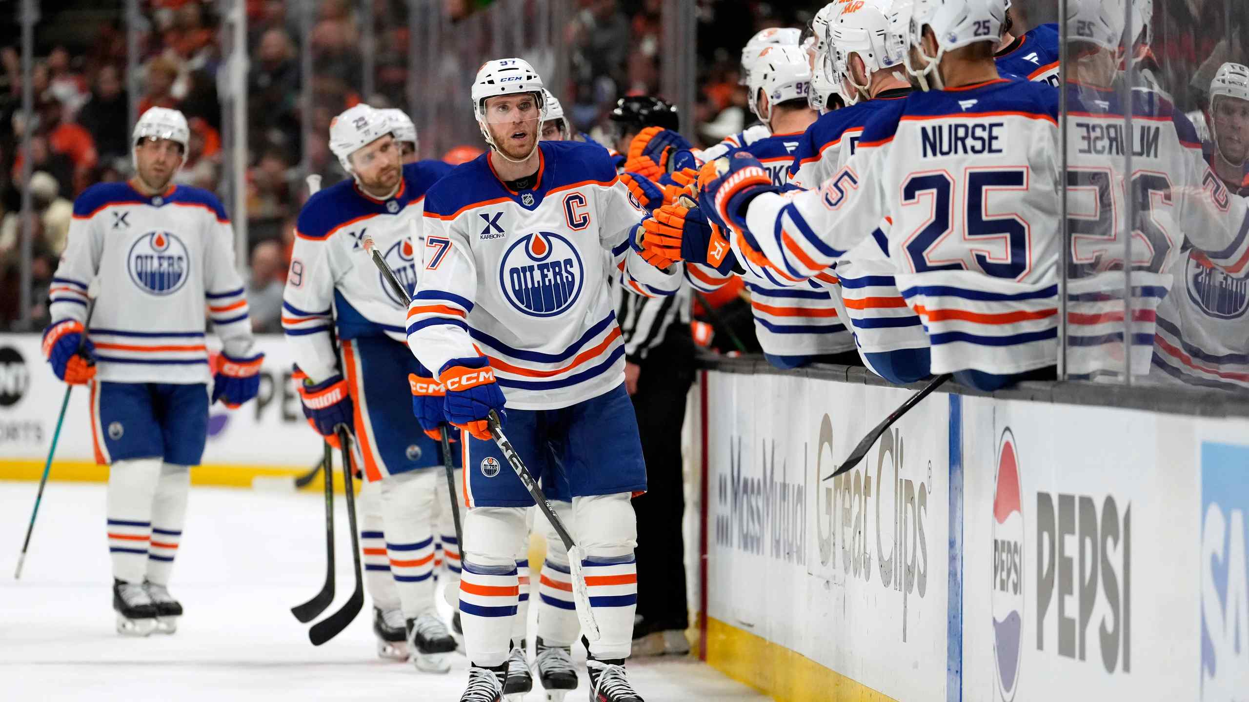 Connor McDavid getting congratulated on the Edmonton Oilers bench.